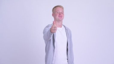 Mutlu sarışın yakışıklı adam kamerayı işaret ediyor.