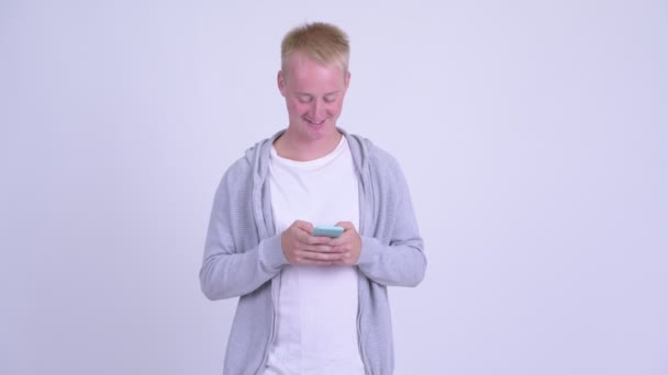 Gelukkig jonge blonde knappe man met behulp van telefoon — Stockvideo