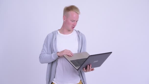 Benadrukte jonge blonde man toont laptop en op zoek boos — Stockvideo