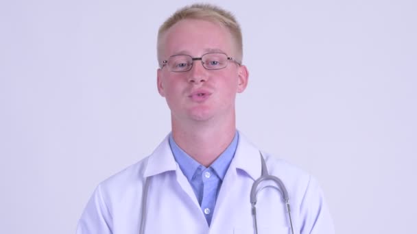 Arca boldog fiatal szőke ember orvos beszél kamera — Stock videók