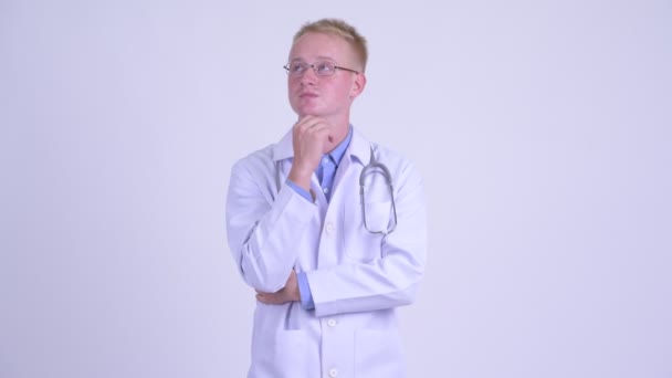 Glücklich junge blonde Mann Arzt denken — Stockvideo