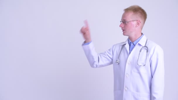 幸せな若いブロンドの男の医者は何かに触れる — ストック動画