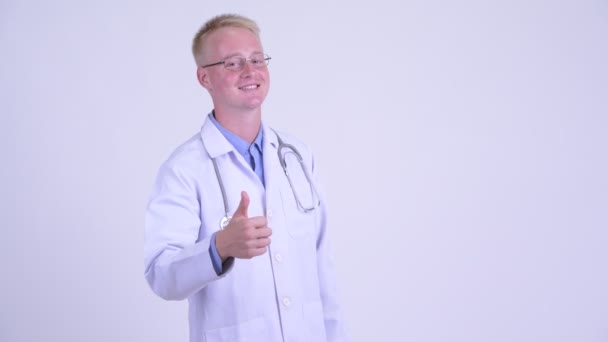 Ευτυχισμένος νέος ξανθός/ιά άνθρωπος γιατρός δίνοντας αντίχειρες επάνω — Αρχείο Βίντεο