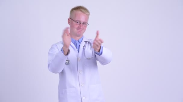 Happy young blonde man doctor clapping hands — Stock Video