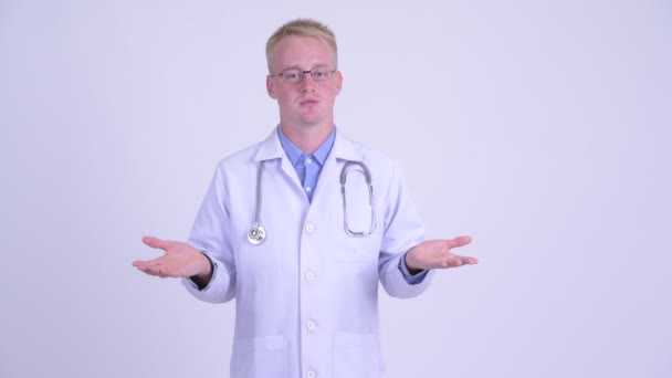 Ledsen ung blond man läkare pratar med kamera — Stockvideo