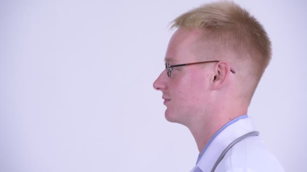 Profile view of happy young blonde man doctor smiling — Stock Video