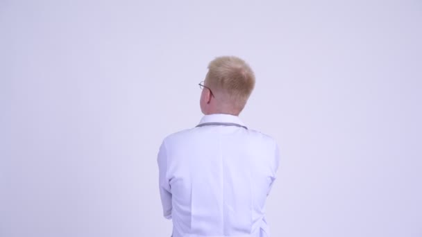 Vue arrière du jeune homme blond médecin dirigeant et pointant du doigt — Video