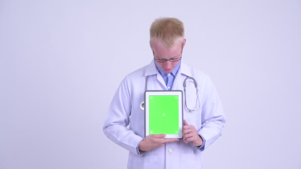 Молодой блондин врач представляет во время показа цифрового планшета — стоковое видео