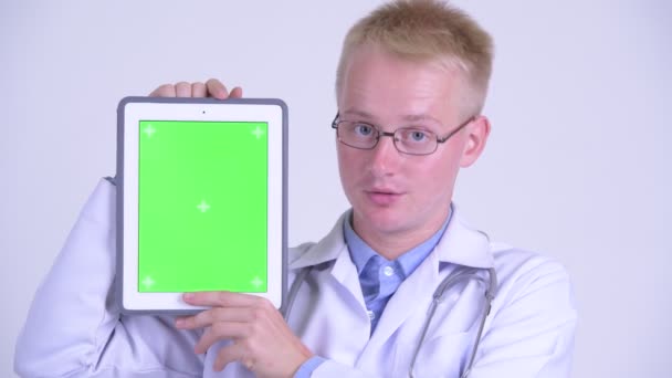 Volto di felice giovane bionda uomo medico mostrando tablet digitale — Video Stock