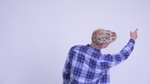 Zadní pohled na mladého hipsterského muže ukazujícího prstem — Stock video