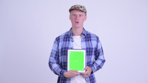Lycklig ung hipster man visar Digital Tablet och ser förvånad — Stockvideo