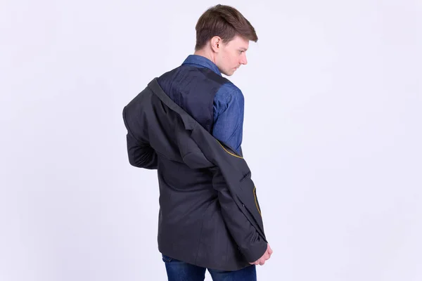 スーツ脱衣ジャケットの若いハンサムなビジネスマンの背面図 — ストック写真