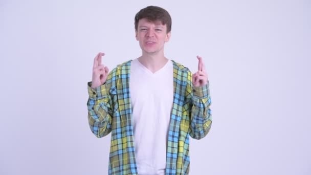 Mladý pohledný muž si přeje se zkříženými prsty — Stock video