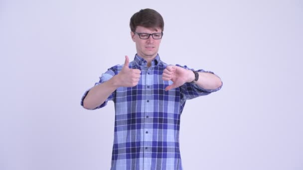 Confused young hipster man choosing between thumbs up and thumbs down — Stock Video