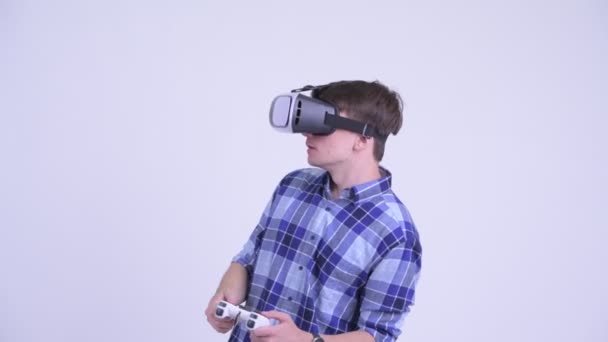 Счастливый молодой хипстер, играющий в игры с гарнитурой виртуальной реальности — стоковое видео