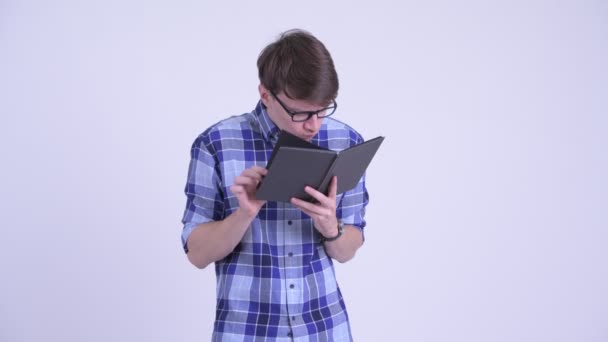 Shy young hipster man covering face with book — Stock Video