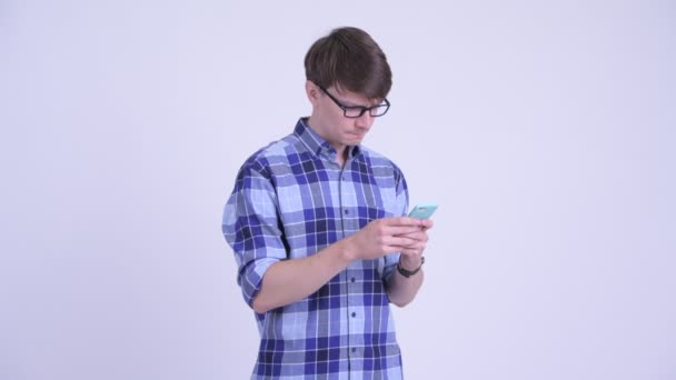 Feliz joven guapo hipster hombre pensando mientras usa el teléfono — Vídeos de Stock