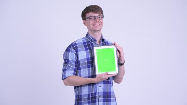 Happy young handsome hipster man thinking while showing digital tablet — Stock Video