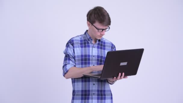 Jovem feliz hipster bonito homem pensando ao usar laptop — Vídeo de Stock