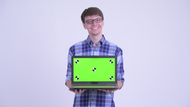 Feliz joven guapo hipster hombre pensando mientras que muestra el ordenador portátil — Vídeo de stock
