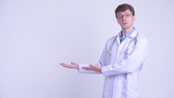 Glücklicher junger Mann Arzt spricht und zeigt etwas — Stockvideo