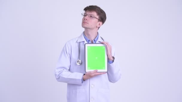 Heureux jeune homme médecin penser tout en montrant tablette numérique — Video