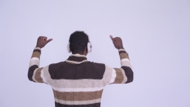 Bakifrån av ung lycklig afrikansk man med nävar upp redo för vintern — Stockvideo