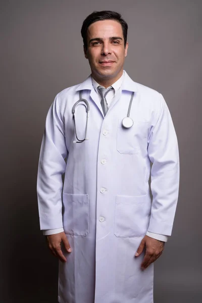 Красивый персидский врач на сером фоне — стоковое фото