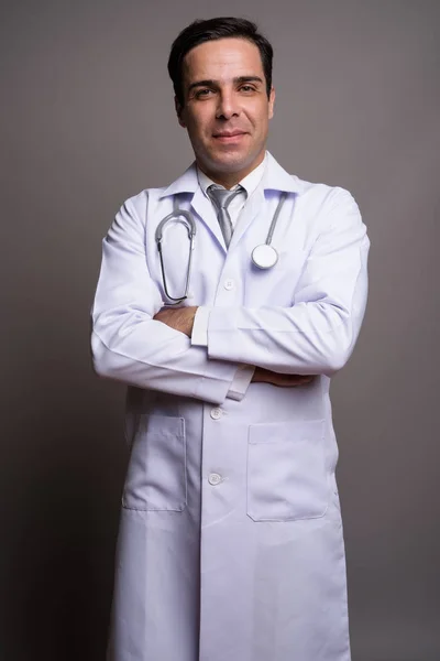 Guapo persa hombre médico contra gris fondo — Foto de Stock