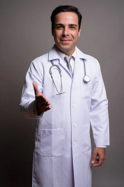 Красивый персидский врач на сером фоне — стоковое фото