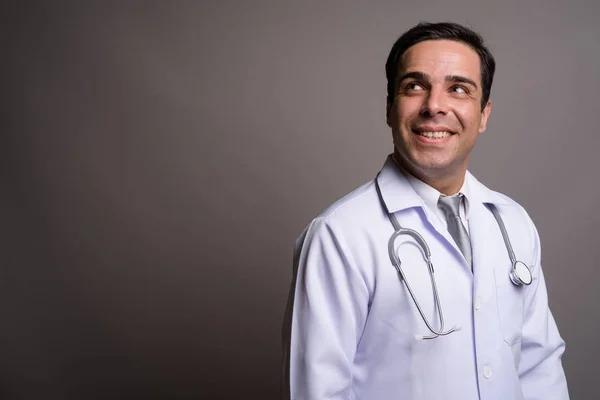 Guapo persa hombre médico contra gris fondo —  Fotos de Stock