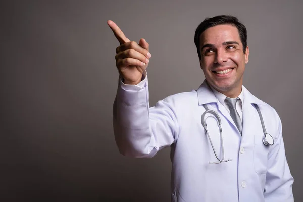 Guapo persa hombre médico contra gris fondo — Foto de Stock