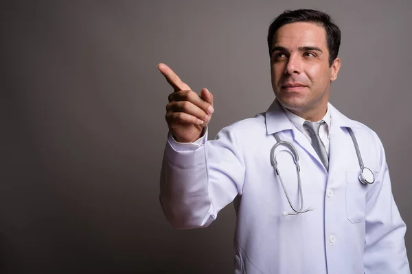 Przystojny perski lekarz mężczyzna przed szarym tle — Zdjęcie stockowe