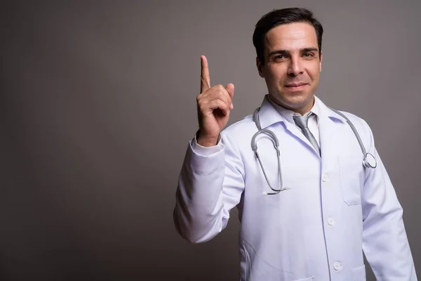 Guapo persa hombre médico contra gris fondo — Foto de Stock