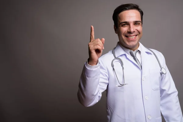 Pohledný perský doktor proti šeděmu pozadí — Stock fotografie