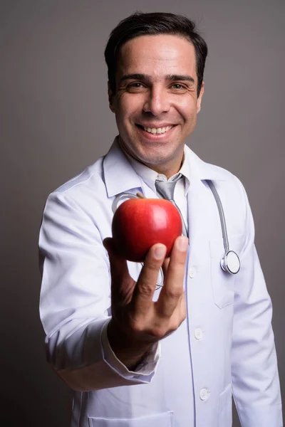 Przystojny perski lekarz mężczyzna przed szarym tle — Zdjęcie stockowe