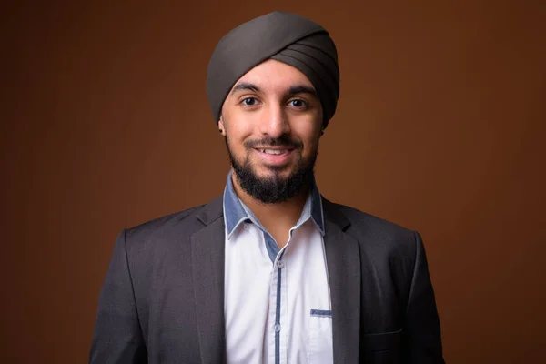 Young bearded Indian Sikh businessman wearing turban against bro — 스톡 사진