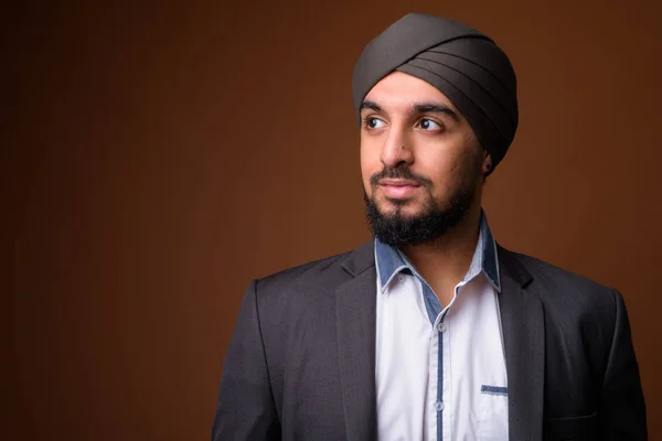 Young bearded Indian Sikh businessman wearing turban against bro — 스톡 사진