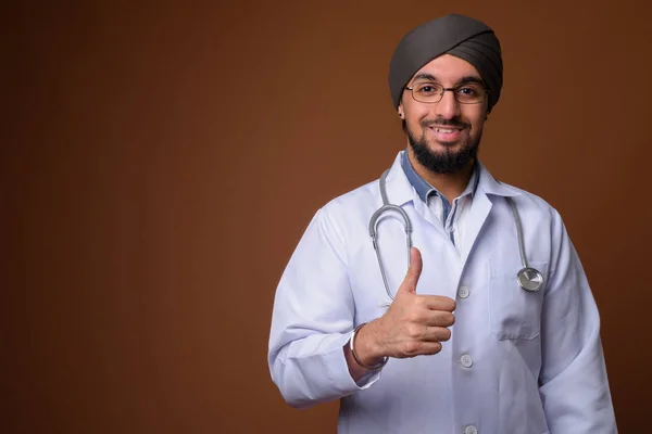 Joven barbudo indio Sikh hombre médico con turbante contra la frente — Foto de Stock