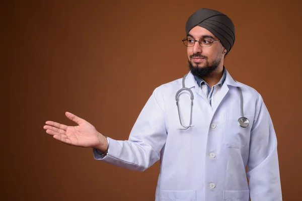 Joven barbudo indio Sikh hombre médico con turbante contra la frente — Foto de Stock