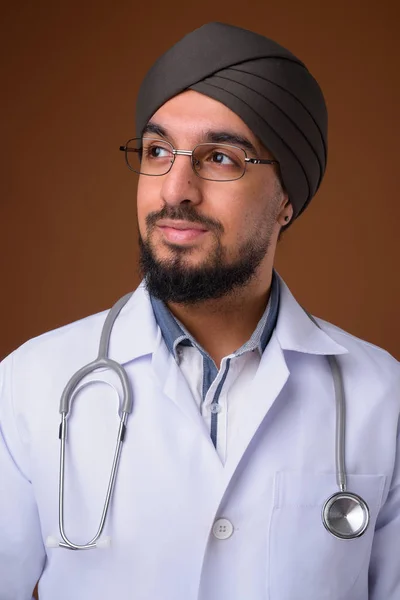 Jovem barbudo indiano sikh homem médico vestindo turbante contra sobrancelha — Fotografia de Stock