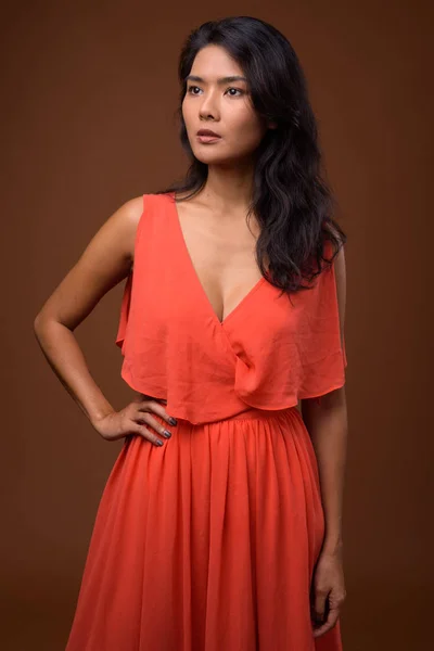 Studio colpo di bella donna asiatica contro sfondo marrone — Foto Stock