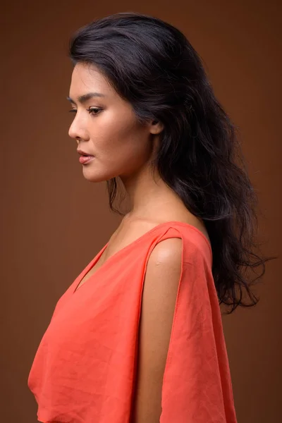 Studio lövés a gyönyörű ázsiai nő ellen, barna háttér — Stock Fotó
