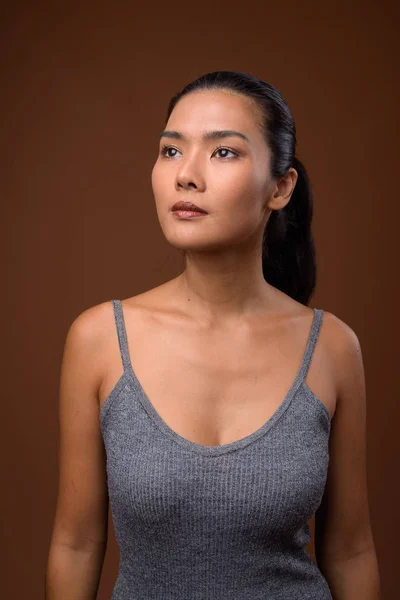 Estudio disparo de hermosa mujer asiática sobre fondo marrón —  Fotos de Stock