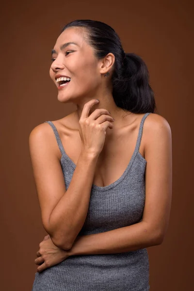 Estudio disparo de hermosa mujer asiática sobre fondo marrón — Foto de Stock