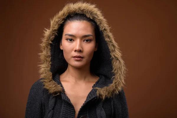 Kahverengi arka plan karşı güzel Asyalı kadın Stüdyo çekim — Stok fotoğraf