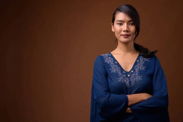 Kahverengi arka plan karşı güzel Asyalı kadın Stüdyo çekim — Stok fotoğraf