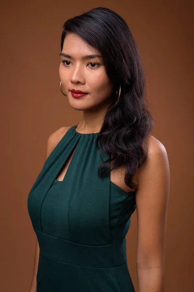 Studio colpo di bella donna d'affari asiatica contro il dorso marrone — Foto Stock