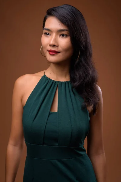 Studio colpo di bella donna d'affari asiatica contro il dorso marrone — Foto Stock