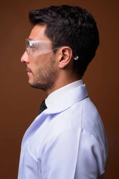 若いですハンサムなヒスパニック系男性医師に対して茶色の背景 — ストック写真